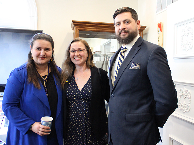 Sarah and her husband Peter, dressed in business attire, standing with the Ambassador of Ukraine to the US, who is wearing a bright blue jacket